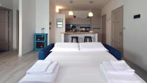 a large white bed in a room with a kitchen at Grecalotto Apartment in La Maddalena