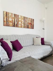 un sofá en una sala de estar con una pintura en la pared en Aricobé, en Palaia Epidavros