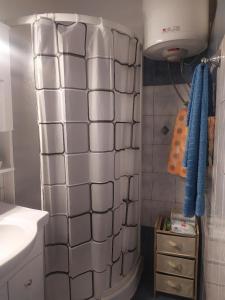 y baño con ducha y paredes de azulejos blancos. en Small and cosy appartment- Piccolina, en Loutraki