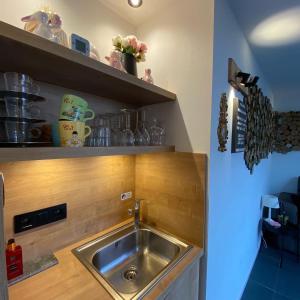 uma cozinha com um lavatório num armário de madeira em B&B Le Jardin de Sophie em Geraardsbergen