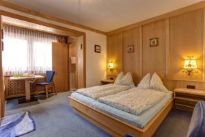a bedroom with a bed and a desk and a table at Alpenruh in Pettneu am Arlberg