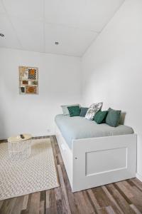 ein weißes Sofa in einem weißen Zimmer mit einem Tisch in der Unterkunft La Suite Classic in Maubeuge