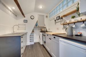 una cocina con armarios blancos y una escalera en Percy Apartments by Week2Week, en Tynemouth