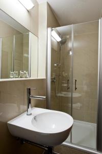 ein Badezimmer mit einem weißen Waschbecken und einer Dusche in der Unterkunft Artim Hotel in Berlin