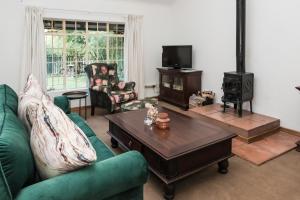 a living room with a couch and a wood stove at Willow Cottage in Dullstroom