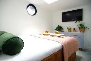 Un dormitorio con una cama con un televisor en la pared. en Magnificent houseboat with a stunning view!, en Ámsterdam