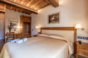 Palazzo del Mercante في مونتيبولسيانو: غرفة نوم مع سرير أبيض كبير في غرفة