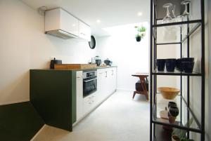 Una cocina con gabinetes blancos y un horno de estufa. en Magnificent houseboat with a stunning view!, en Ámsterdam 12 fotos más