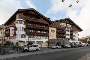 een groot gebouw met auto's geparkeerd voor het bij Das Kaltschmid - Familotel Tirol in Seefeld in Tirol