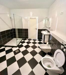 ein Bad mit schwarz-weiß kariertem Boden in der Unterkunft Apartments Family in Tivat