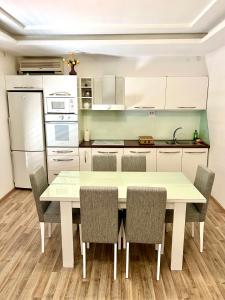 eine Küche mit einem weißen Tisch und Stühlen in der Unterkunft Apartments Family in Tivat