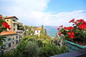 een uitzicht op een stad met rode bloemen in een pot bij MAL Portovenere Apartment in Portovenere