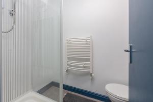 a white bathroom with a toilet and a shower at Blackpool Lodge Apartments in Blackpool +21 photos