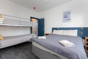 two beds in a room with blue walls at Blackpool Lodge Apartments in Blackpool