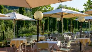a patio area with tables, chairs and umbrellas at Tenuta Sovestro in San Gimignano