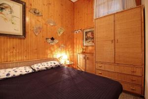 a bedroom with a bed and a wooden wall at MAL Portovenere Apartment in Portovenere