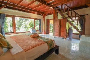 Un dormitorio con una cama grande en una habitación con ventanas. en Abangan Bungalow, en Ubud 102 fotos más