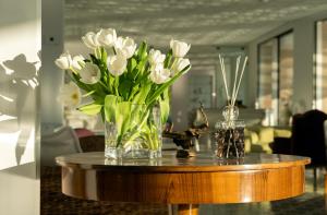un jarrón de flores blancas sentado en una mesa en Hotel Belair, en Sorrento