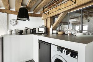 uma cozinha com um balcão branco e uma máquina de lavar louça em Apartment Saint Germain des Prés by Studio prestige em Paris
