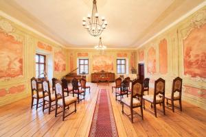 ozdobny pokój ze stołem, krzesłami i żyrandolem w obiekcie Penzion Zámek Lešany w mieście Netvořice
