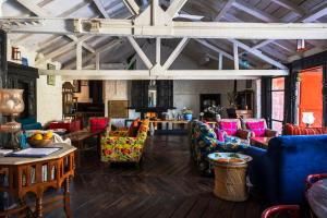 a living room with colorful chairs and tables at ROSASTAYS Jeolikote in Nainital