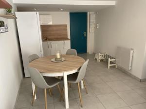 - une table à manger et des chaises dans la cuisine dans l'établissement Appartement climatisé avec cour en centre ville, à Carpentras