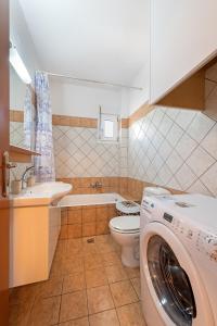 a bathroom with a washer and a washing machine in it at Lagadi Apartment 8 in Lassi