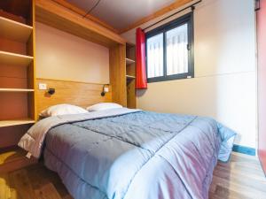 1 dormitorio con cama y ventana en Camping 3 étoiles A La Corniche La Rochelle Angoulins, en Angoulins-sur-Mer