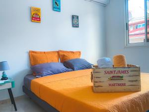 Una habitación con una cama con una caja. en KAZANTILLAISE STE LUCE T3, en Sainte-Luce
