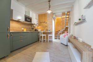 cocina y sala de estar con armarios verdes y mesa en B&B Le Casette Chieti en Chieti