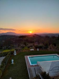 einen Sonnenuntergang über einem Pool mit Sonnenuntergang in der Unterkunft La Moresca - Casa Vacanze in Poggio Mirteto