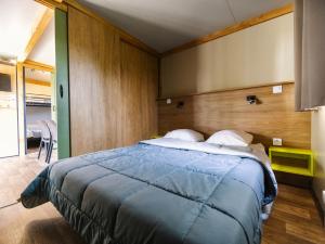 a bedroom with a large bed with a blue blanket at Camping Paradis 4 étoiles A La Corniche La Rochelle Angoulins in Angoulins-sur-Mer