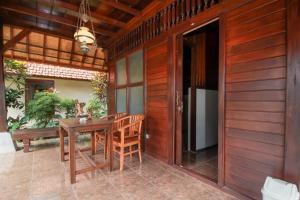 a wooden dining room with a wooden table and chairs at Abangan Bungalow in Ubud