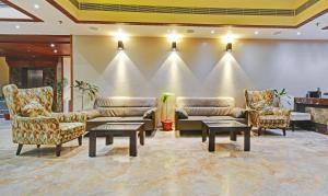 a lobby with couches and tables and a wall at Hotel Mandovin Near Railway Station in Udaipur +40 photos