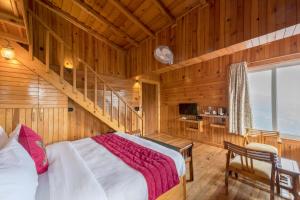 a bedroom with a bed in a wooden room at ROSASTAYS Vatika - Mountain View in Rāmgarh