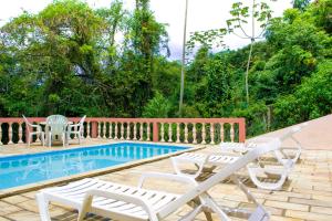 a patio with chairs and a swimming pool at Pousada Canto do Curió Paraty in Paraty