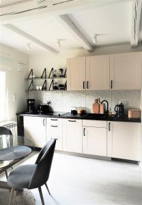 a kitchen with white cabinets and a glass table at Przytulny apartament SUDECKI KLIMAT by SpaceApart in Szklarska Poręba