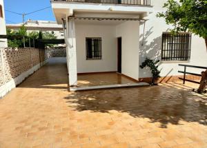 Casa CHALET INDEPENDIENTE en CALLE PRIVADA في Los Mártires: منزل أبيض مع ممر من الطوب