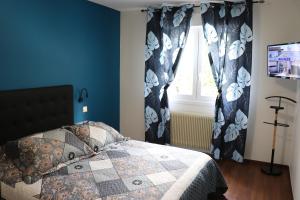 a bedroom with a bed with blue walls and a window at Gîte les Pervenches avec Sauna in Gérardmer