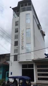 a white building with a sign on it at Tarapoto Hostal *** in Iquitos