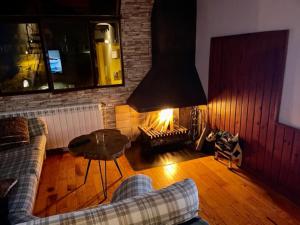 - un salon avec un canapé et une cheminée dans l'établissement DÚPLEX La MOLINA a 5 minutos de las pistas de esquí, à La Molina