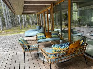 eine Veranda mit Stühlen und einem Tisch auf einer Terrasse in der Unterkunft Villa Hausma in Hiiumaa