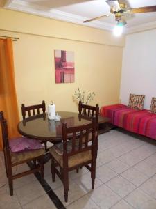 sala de estar con mesa, sillas y cama en 200 metros peatonal en San Miguel de Tucumán