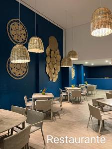 a restaurant with tables and chairs and chandeliers at Flat praia dos carneiros eco resort 26 in Tamandaré