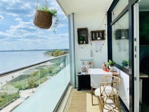 a balcony with a table and a view of the water at Ostsee Liebe in Neustadt in Holstein
