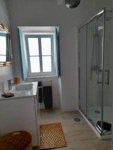 a bathroom with a sink and a shower with a window at Carlo's Beach Guest House in Odeceixe