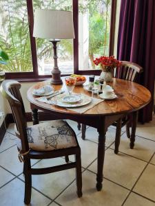 a wooden table with a lamp and a plate of food at Cherry Berry Guest House in George