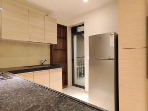 OSI Apartments BKC Kurla West في مومباي: مطبخ مع ثلاجة ستيل ستانلس ودواليب خشبية