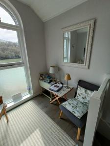 a living room with a chair and a mirror at Beautiful 1-Bed Riversi Cottage Located in Malpas in Truro