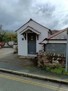mały biały budynek z zielonymi drzwiami na ulicy w obiekcie Beautiful 1-Bed Riversi Cottage Located in Malpas w mieście Truro